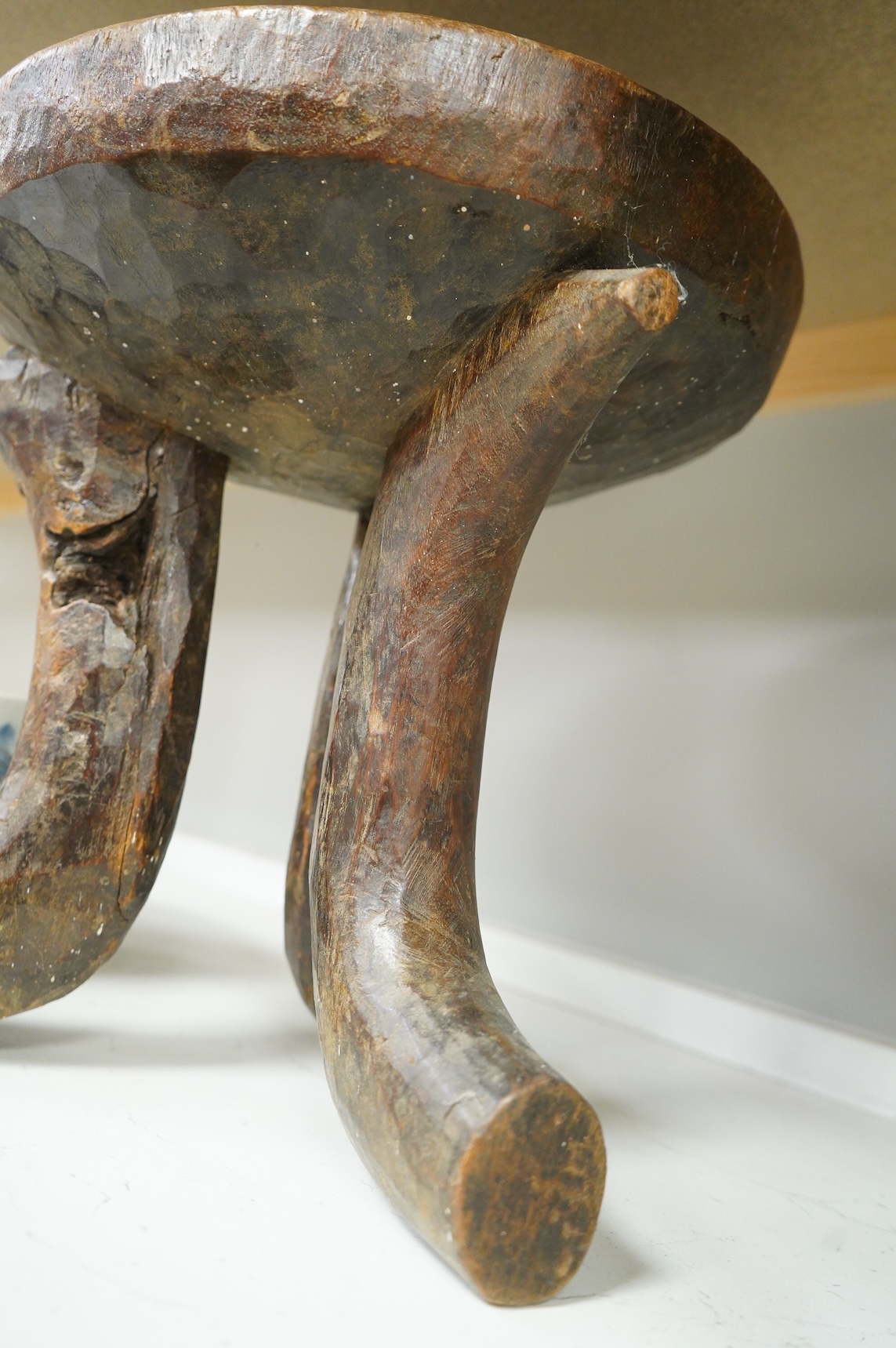 An Ethiopian tribal three footed stool and a carved handled bowl, stool 33cm high
